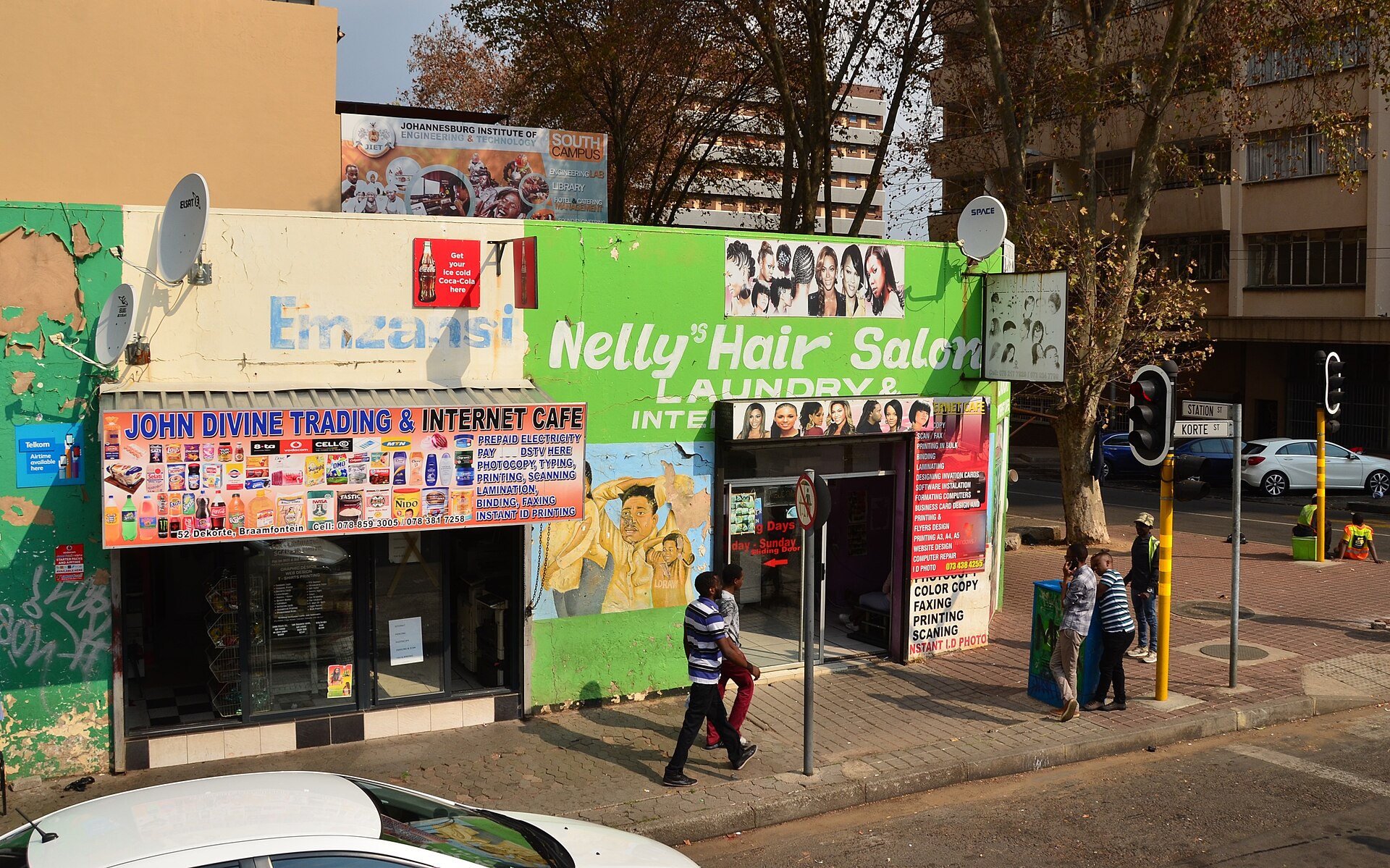 Nelly’s Hair Salon & Internet Cafe on a Braamfontein street corner, with signage for both businesses.